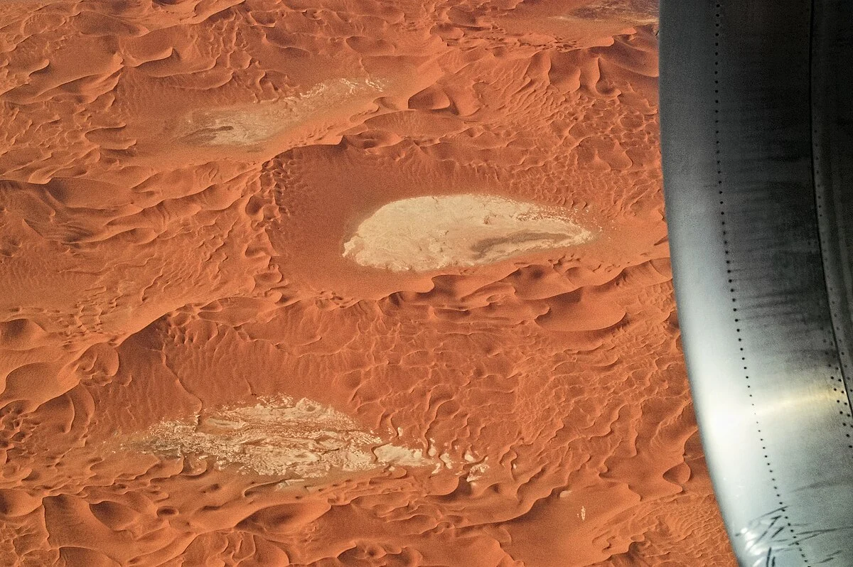 Luftaufnahme von pastellfarbenen Sanddünen und abflusslosen Senken (Sebkhas) in der Sahara, Erg Tiffernine, Algerien