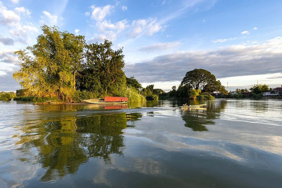 Bäume spiegeln sich im Mekong bei Si Phan Don