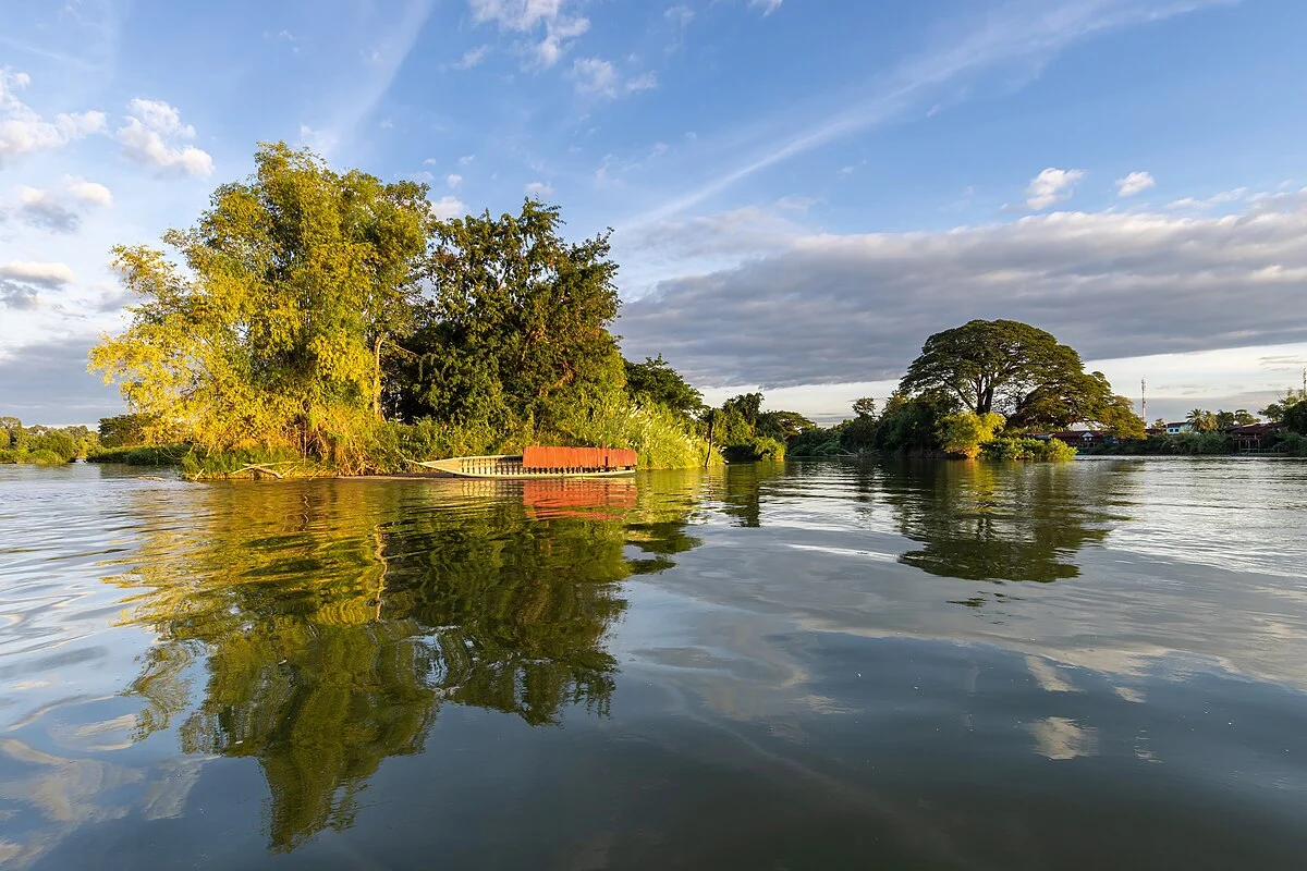 Bäume spiegeln sich im Mekong bei Si Phan Don